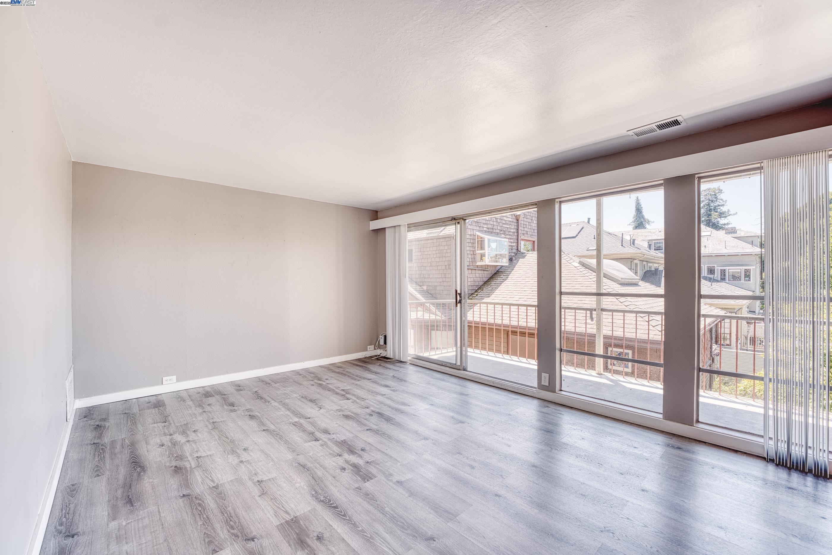 3815 Harrison Street, Unit 103 Oakland, CA 94611 - Photo 6 of 28 wooden floor in an empty room with a window