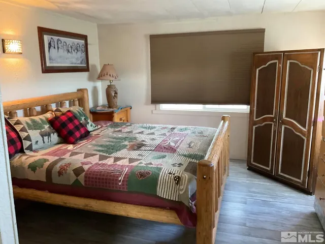 a bedroom with a bed and a refrigerator