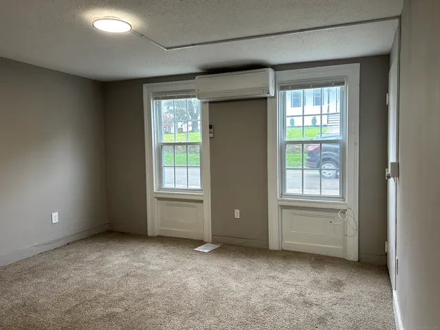 an empty room with windows and closet