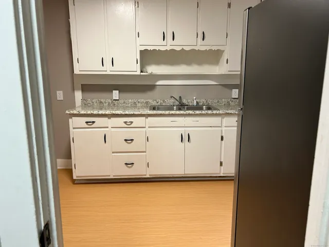 a bathroom with granite countertop a stove and a white cabinet