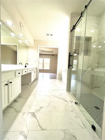 a bathroom with a tub sink shower and mirror