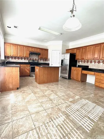 a kitchen with stainless steel appliances a stove a sink cabinets and living room view