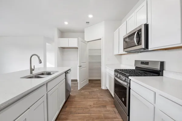 a kitchen with stainless steel appliances granite countertop a sink stove and refrigerator
