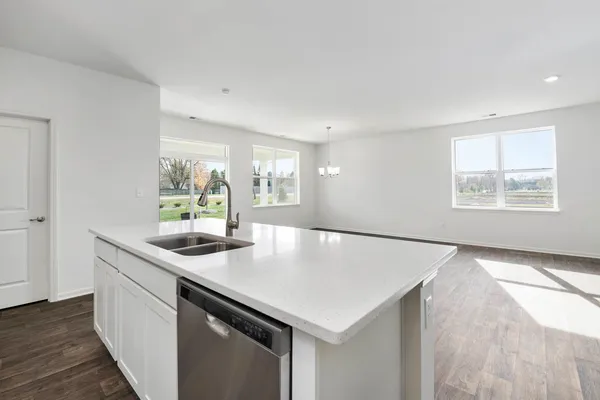 a kitchen with appliances cabinets and wooden floor