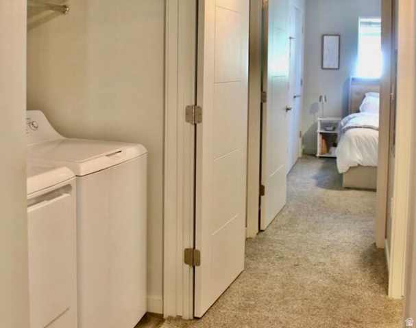 64 West 600 South, Unit C105 Springville, UT 84663 - Photo 11 of 11 Convenient laundry area featuring a white top-load washer and dryer set, adjacent to a hallway with neutral carpeting
