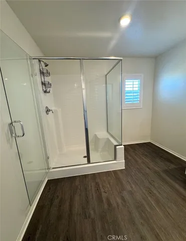a view of a room with wooden floor and white walls