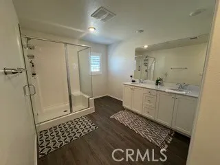 a bathroom with a sink a toilet a mirror and shower