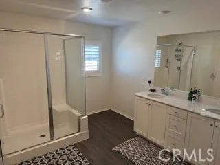 a bathroom with a double vanity sink a mirror and a shower