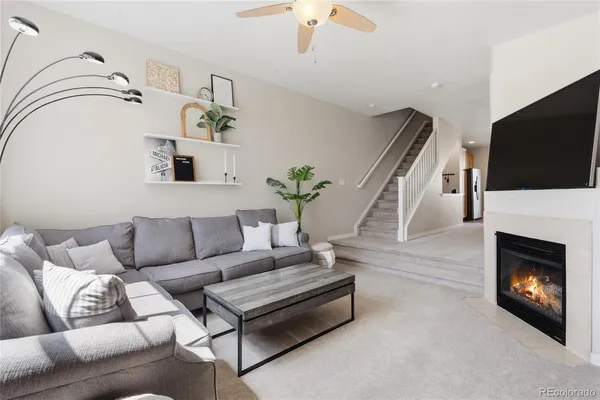 a living room with furniture a flat screen tv and a fireplace