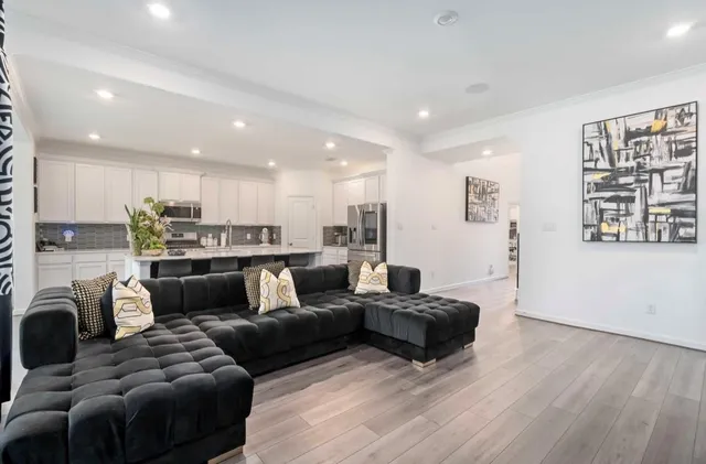 a living room with furniture and a view of kitchen