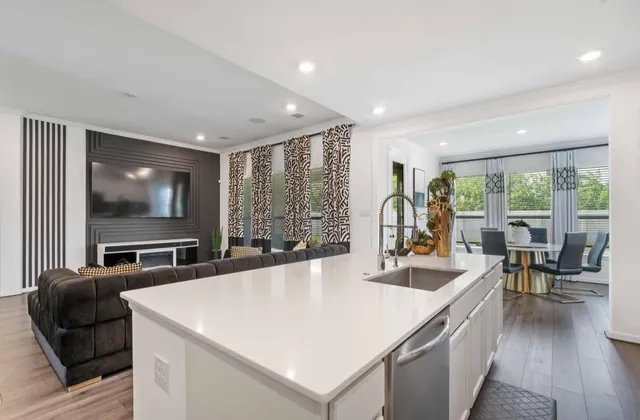 a living room with stainless steel appliances kitchen island granite countertop furniture and a large window