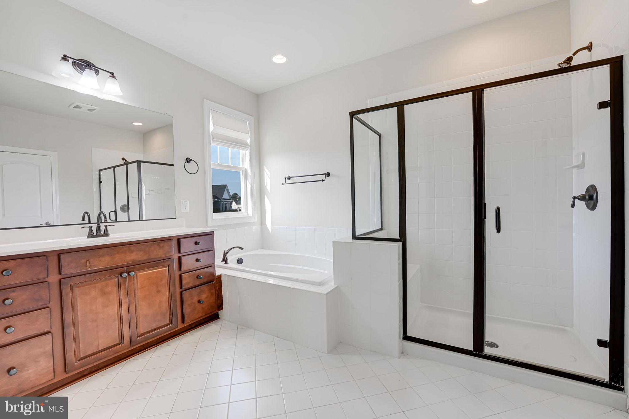 11708 Eagle Ridge Drive Spotsylvania, VA 22551 - Photo 24 of 75 a spacious bathroom with a double vanity sink a mirror and a bathtub