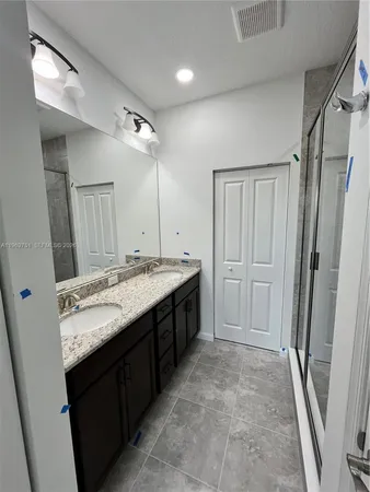 a bathroom with a granite countertop sink a mirror and a bathtub