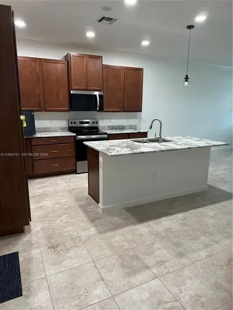 a kitchen with stainless steel appliances granite countertop a sink and a stove