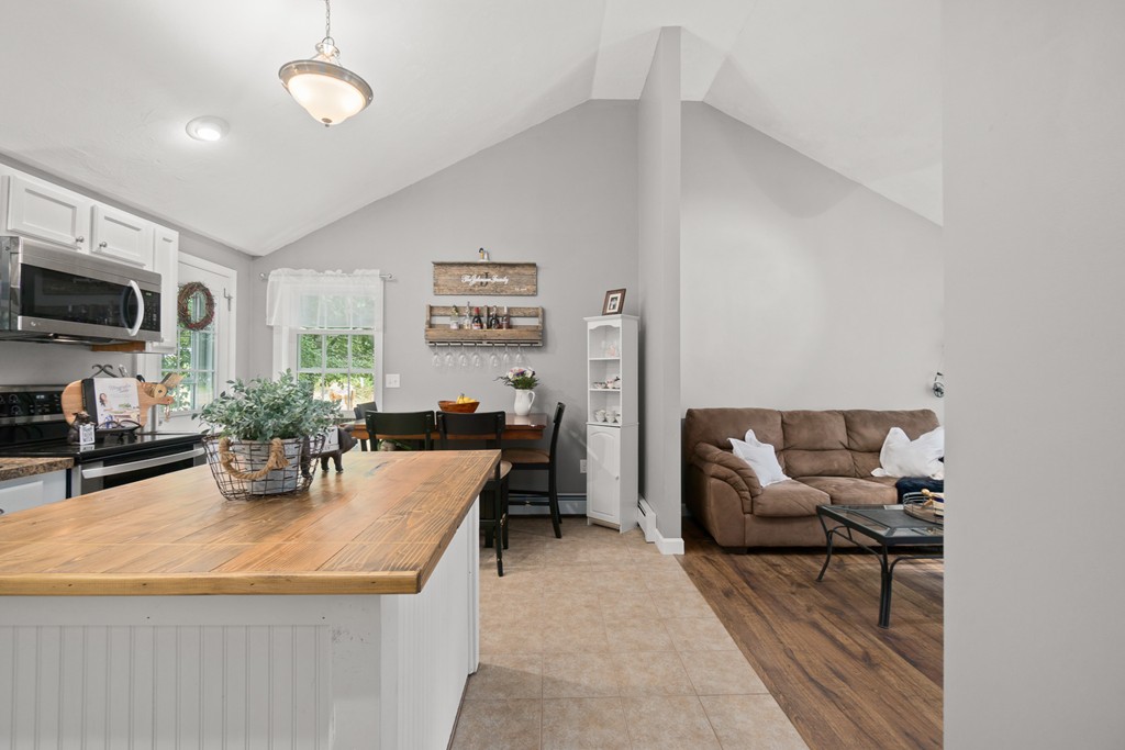 28 Mill Road North Brookfield, MA 01535 - Photo 6 of 29 a living room with furniture a flat screen tv and kitchen view