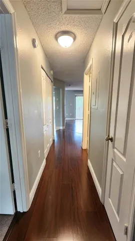 a view of a hallway with wooden floor