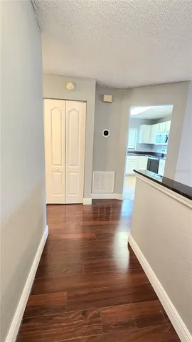 a view of a kitchen with wooden floor and electronic appliances