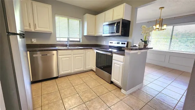 a kitchen with stainless steel appliances granite countertop a stove top oven a sink a counter top space and cabinets