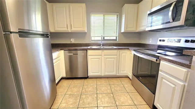 a kitchen with stainless steel appliances granite countertop a refrigerator sink and cabinets