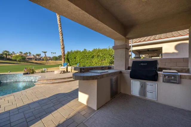 a living room with stainless steel appliances kitchen island granite countertop a sink and cabinets