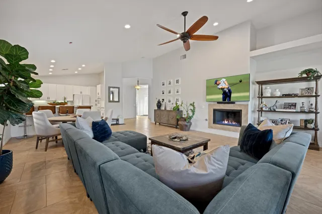 a living room with furniture kitchen view and a potted plant