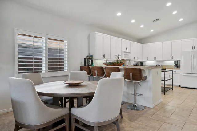 a kitchen with a dining table chairs sink and cabinets
