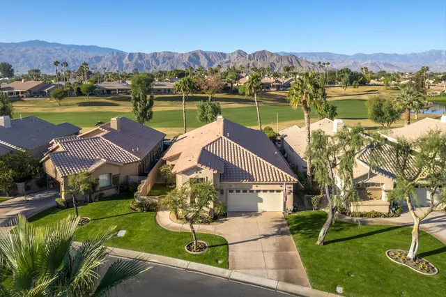 an aerial view of house with yard lake and mountain view in back