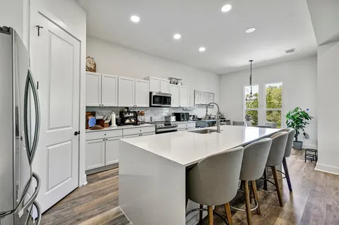 a kitchen with white cabinets and stainless steel appliances