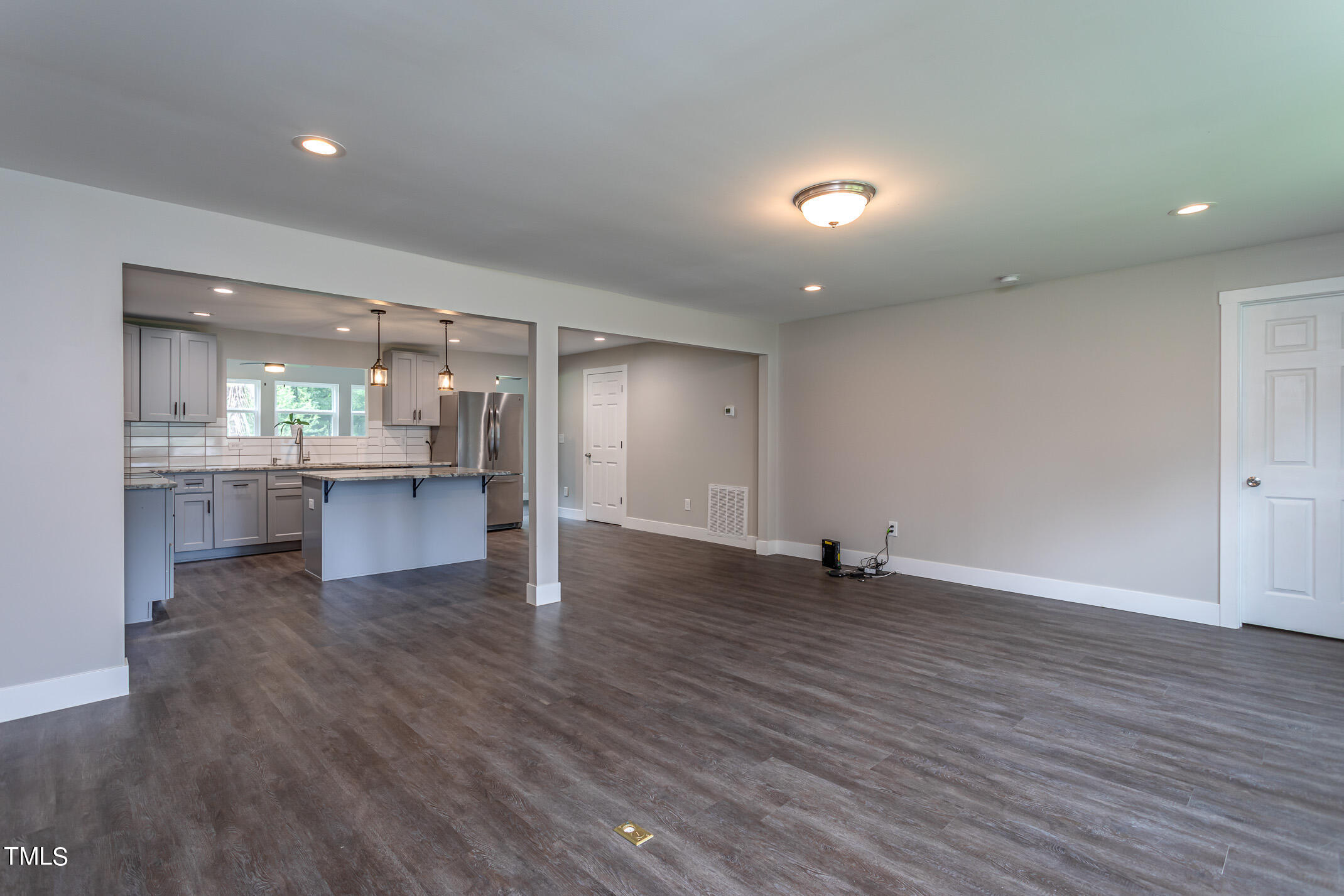 703 Woodland Road Raleigh, NC 27603 - Photo 3 of 26 an empty room with wooden floor and windows