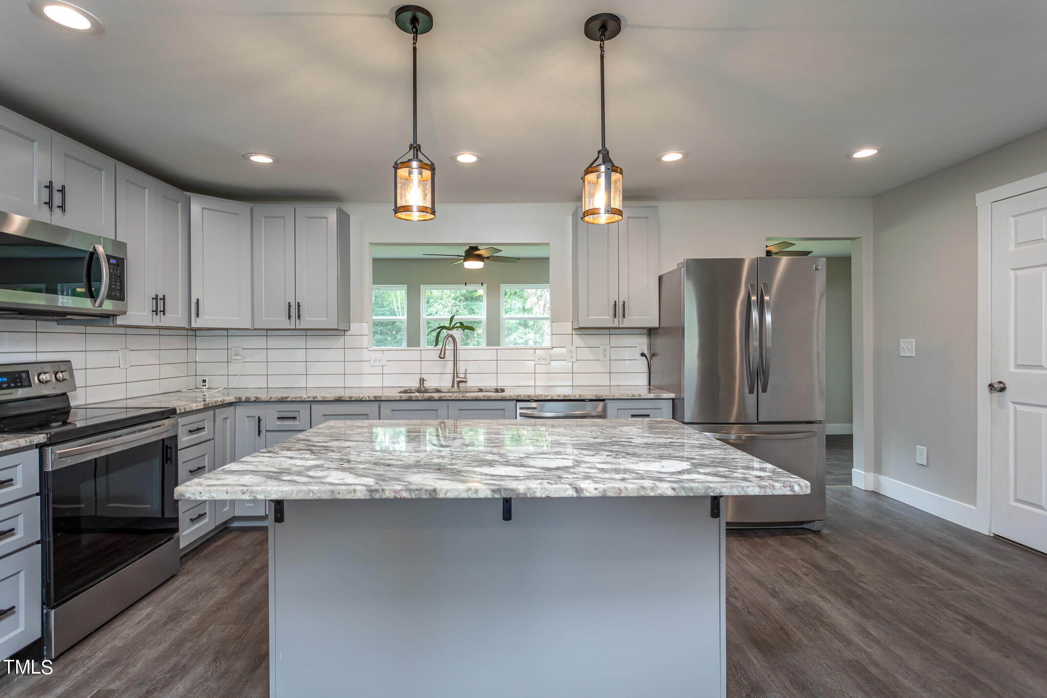 703 Woodland Road Raleigh, NC 27603 - Photo 4 of 26 a kitchen with stainless steel appliances granite countertop a sink refrigerator and microwave