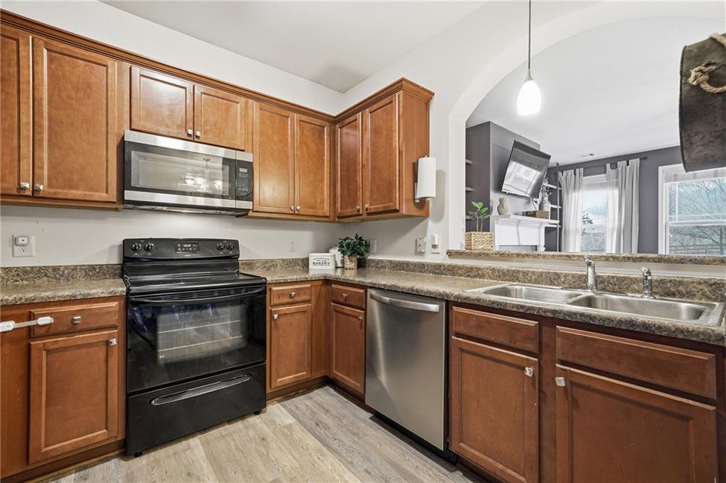 615 Myers Gate Road Ball Ground, GA 30107 - Photo 10 of 43 a kitchen with granite countertop wooden cabinets stainless steel appliances and a sink