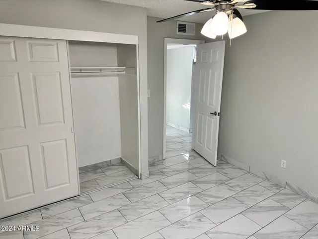 an empty room with a chandelier fan