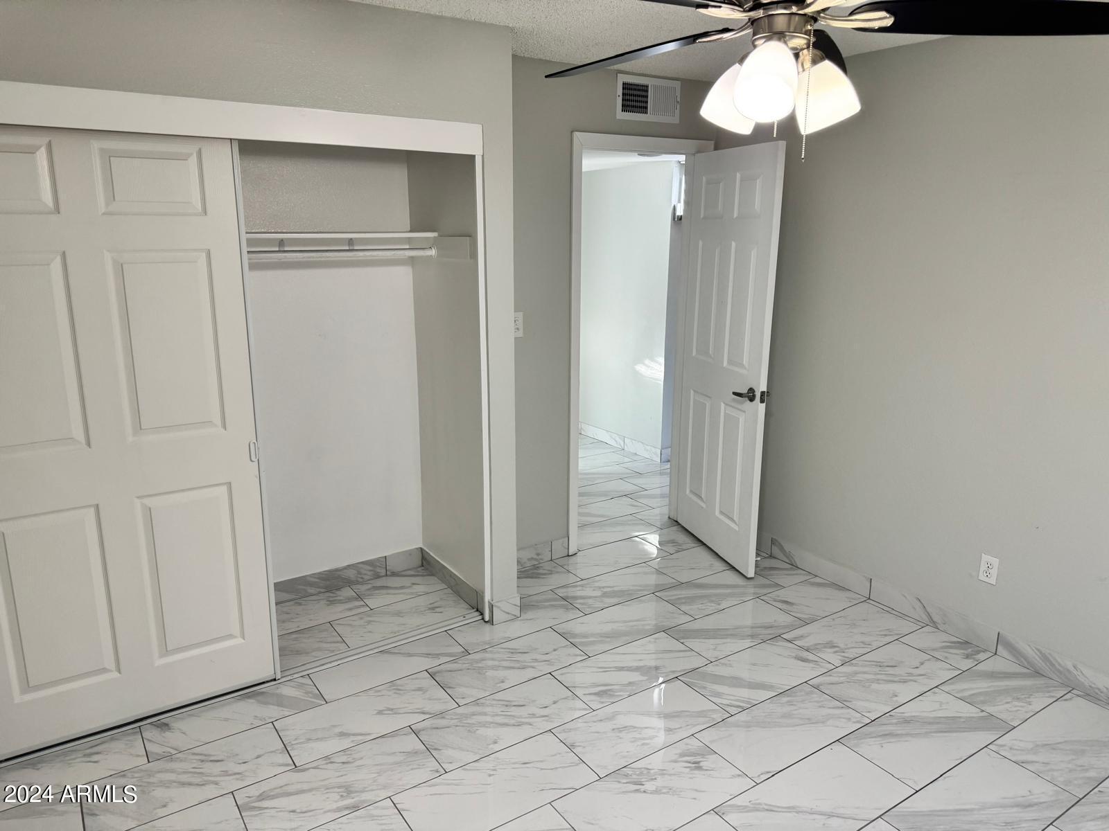 7209 West Luke Avenue Glendale, AZ 85303 - Photo 12 of 19 an empty room with a chandelier fan