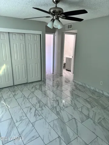 a view of a hallway with a chandelier fan and windows