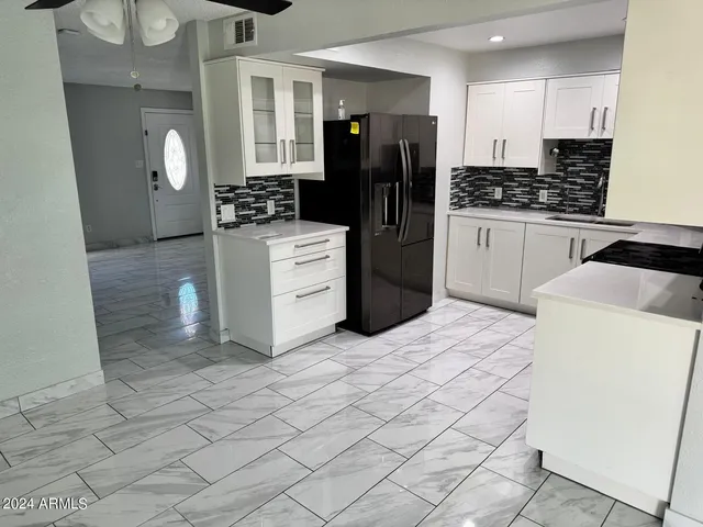 a kitchen with stainless steel appliances kitchen island granite countertop a refrigerator and a stove top oven