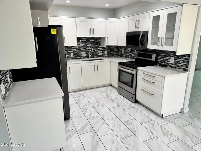 a kitchen with stainless steel appliances a stove a microwave and a refrigerator