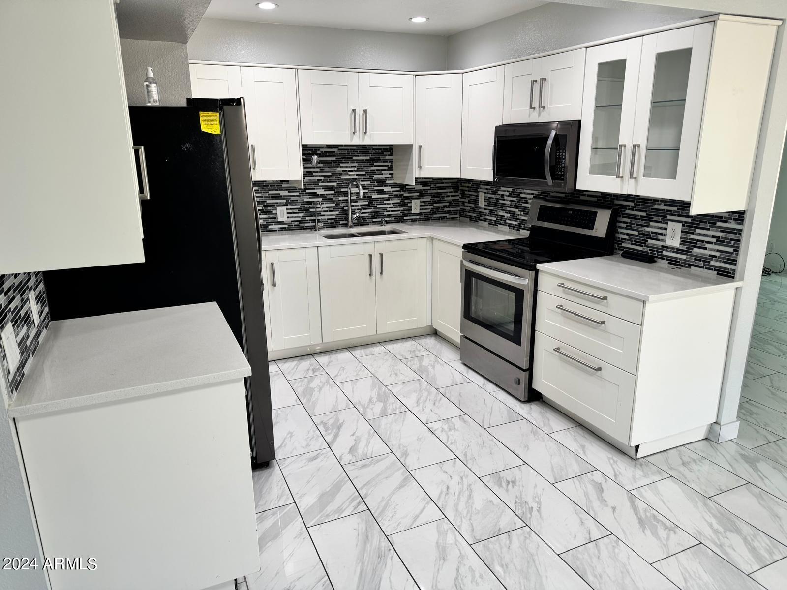 7209 West Luke Avenue Glendale, AZ 85303 - Photo 6 of 19 a kitchen with stainless steel appliances a stove a microwave and a refrigerator