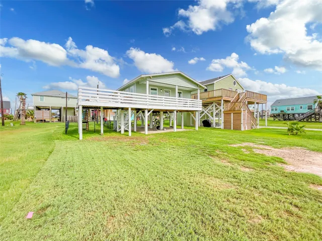 a view of a house with a big yard and large trees