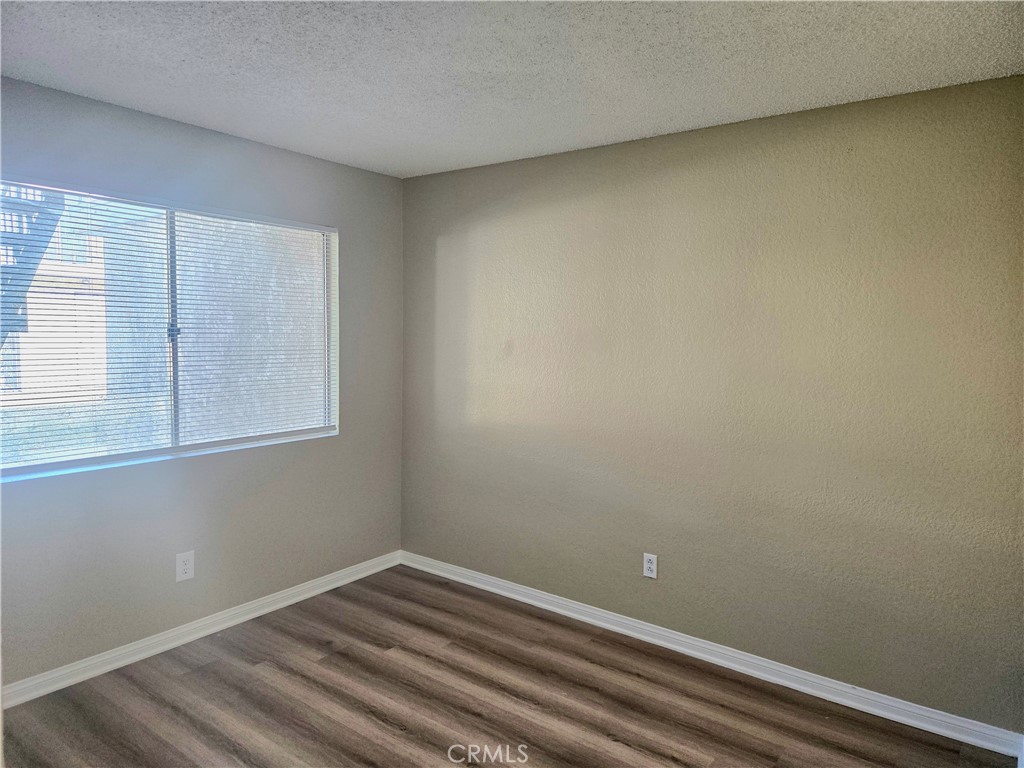 1118 Post Street, Unit B Redlands, CA 92374 - Photo 7 of 14 a view of an empty room with wooden floor and a window