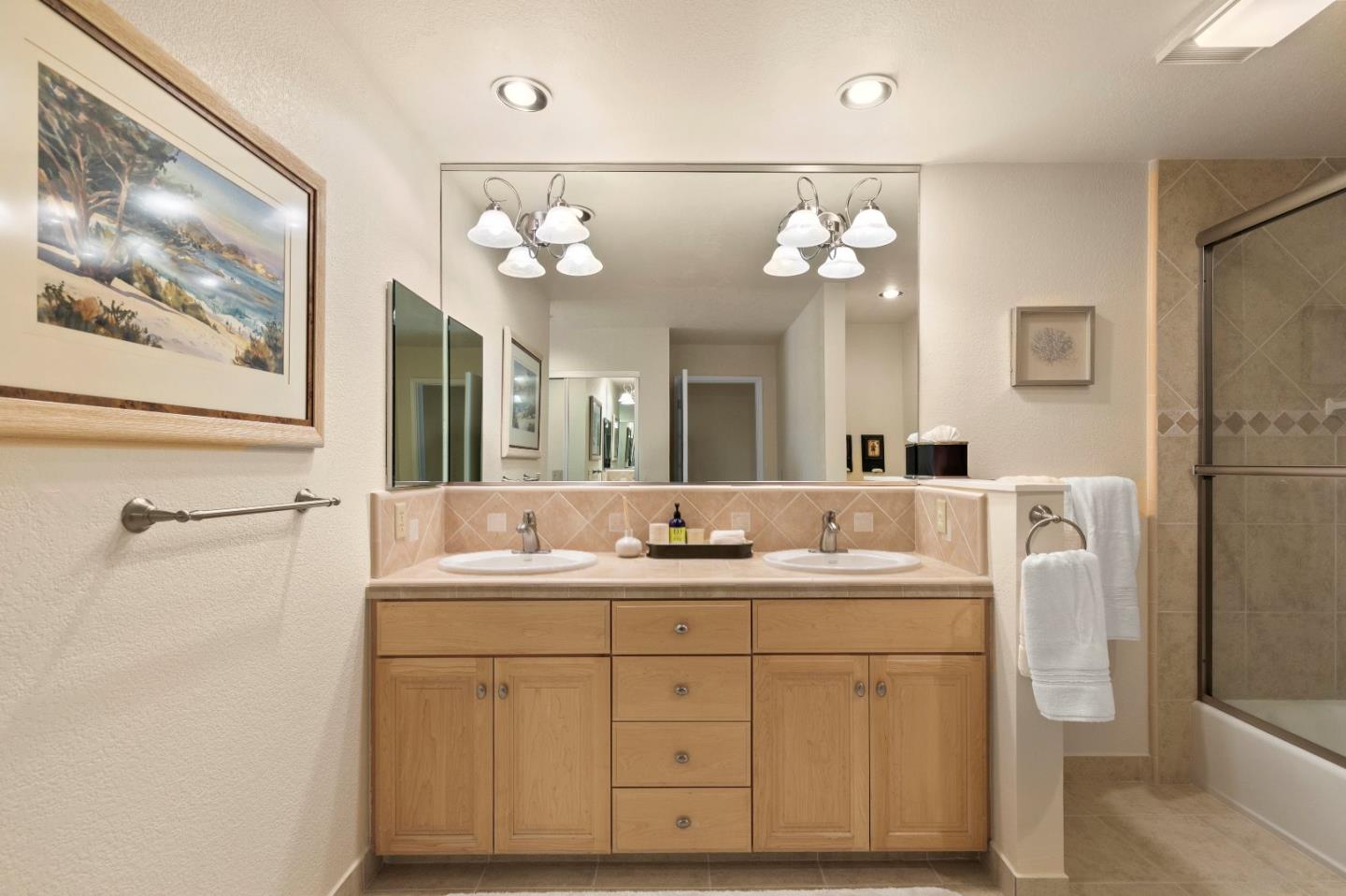 51 Shepherds Knoll Road, Unit 51 Monterey, CA 93940 - Photo 16 of 18 a bathroom with a double vanity sink mirror and a bathtub with a large mirror