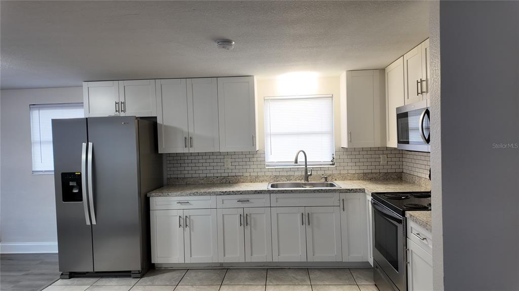 37530 Ferris Avenue Zephyrhills, FL 33542 - Photo 3 of 17 a kitchen with stainless steel appliances granite countertop a refrigerator sink and stove