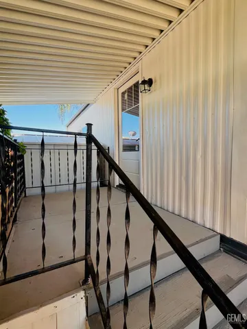 a living room with stainless steel appliances kitchen island wooden floors and white walls