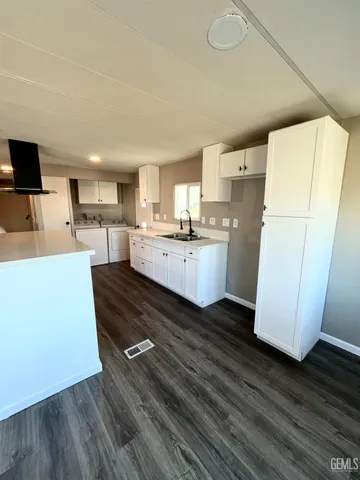 a view of living room with stainless steel appliances wooden floor and view living room