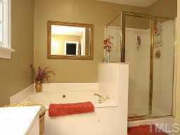 5809 Ventry Court Raleigh, NC 27613 - Photo 4 of 9 a bathroom with a tub sink and mirror