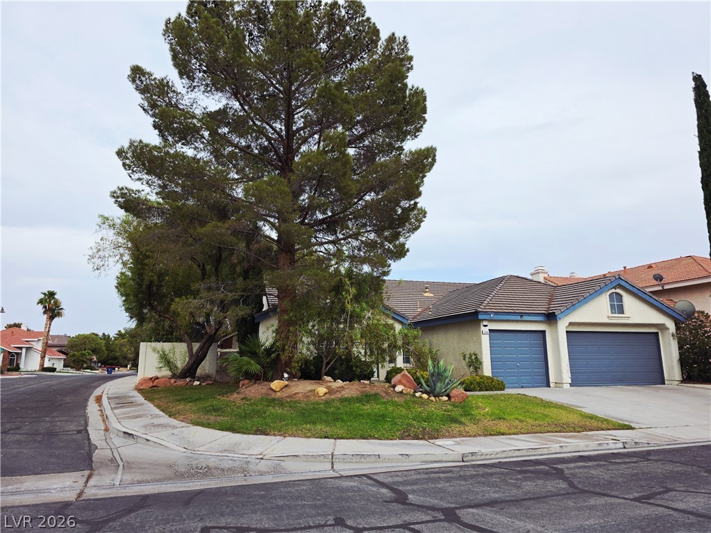 2920 Setting Sun Street Las Vegas, NV 89117 - Photo 2 of 43 A well-maintained suburban residence featuring a tiled roof and dual garage doors.