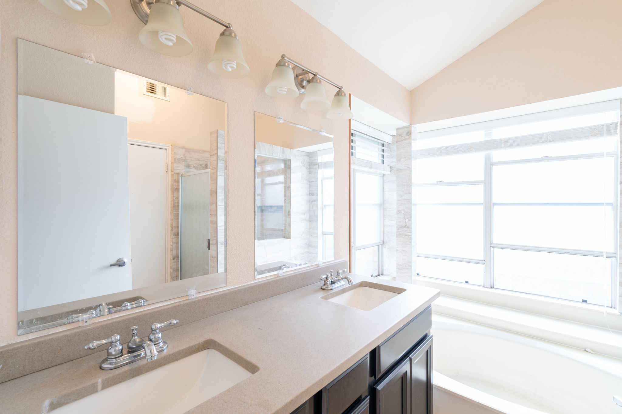 5611 Meadow Crest Austin, TX 78744 - Photo 12 of 26 Bathroom with a stall shower, double vanity, a bath, and vaulted ceiling