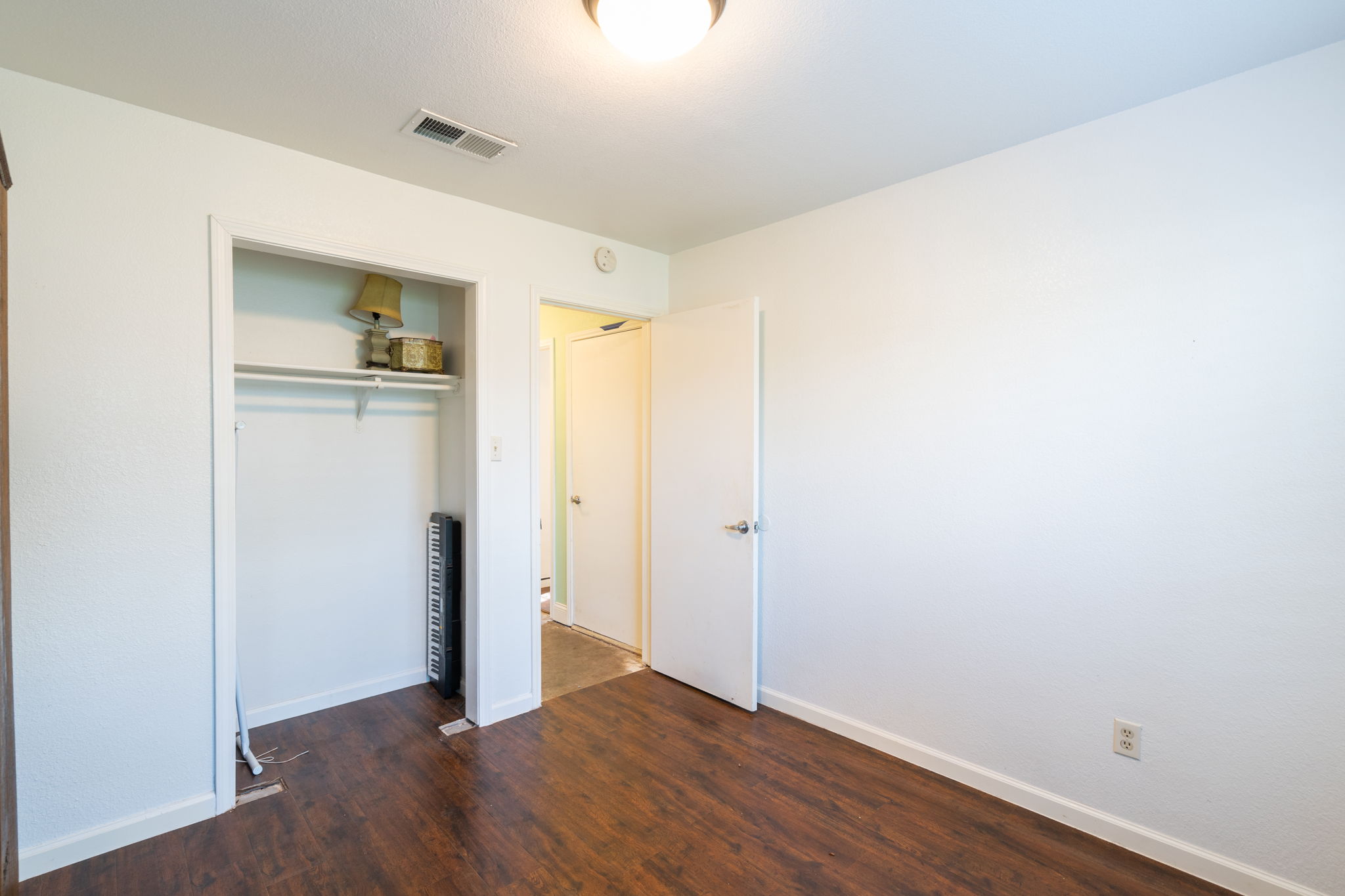 5611 Meadow Crest Austin, TX 78744 - Photo 20 of 26 Unfurnished bedroom featuring dark wood-style flooring and a closet