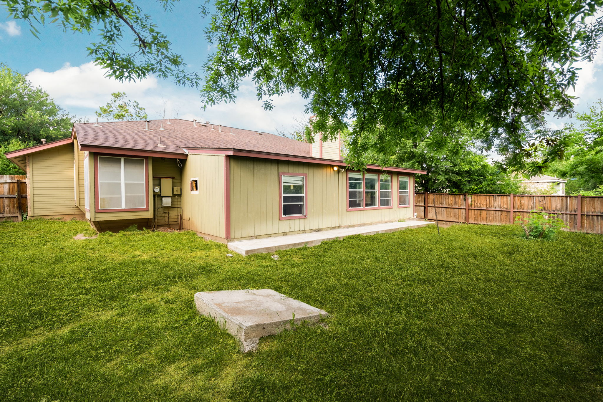 5611 Meadow Crest Austin, TX 78744 - Photo 25 of 26 Rear view of house with a fenced backyard and roof with shingles