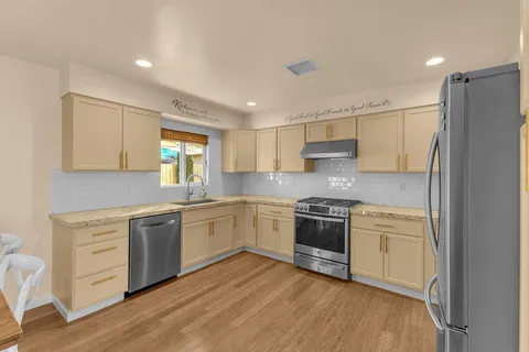 a kitchen with stainless steel appliances granite countertop a stove and a refrigerator