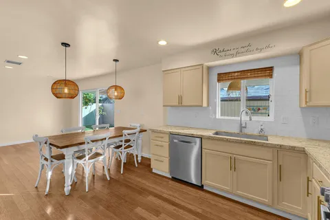 a kitchen with a table chairs sink and cabinets